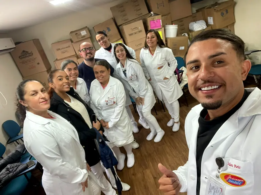 Alunos de jaleco branco reunidos antes de uma campanha de vacinação